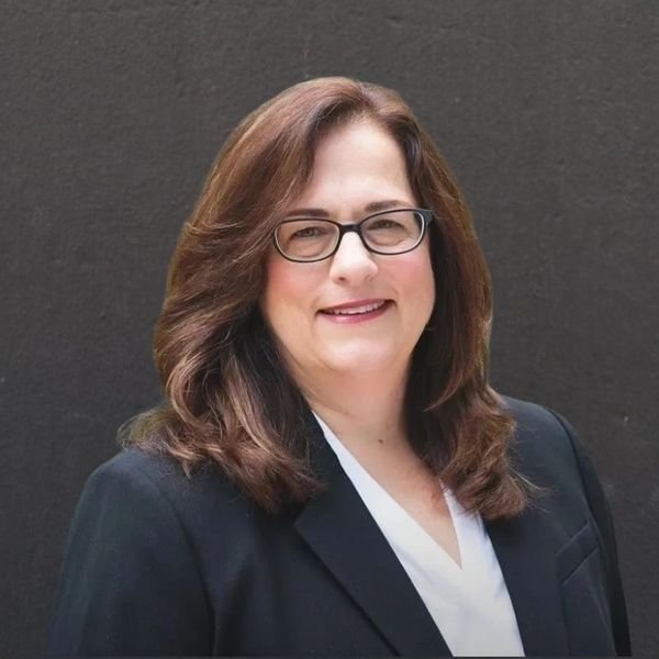Pamela Carrube, professional woman with glasses and brown hair
